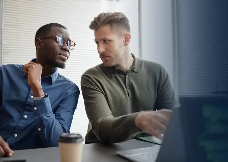 two HR managers using laptop to manage corporate gift program.