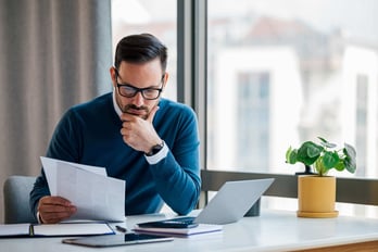 business man sitting at desk looking at gift card distributor options