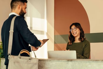 OPT Blog Image - Administration Professional talking to a customer at the front desk.