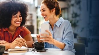 two happy women looking at a digital reward they just received on their phone