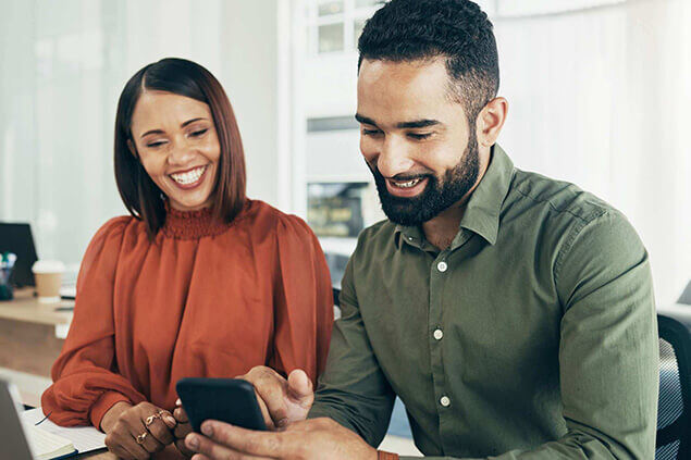 two work colleagues looking at a digital app with rewards on their phone